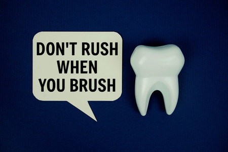 Don't Rush When You Brush text on speech bubble and white tooth model on navy blue backgroud