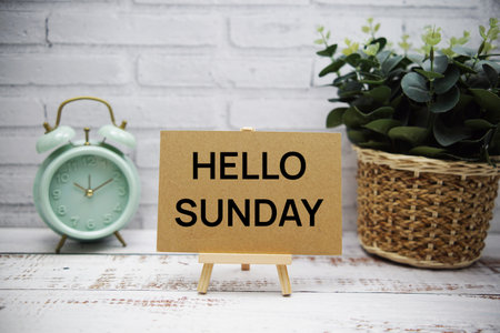 Hello Sunday text message with easel stand on wooden backgroundの写真素材