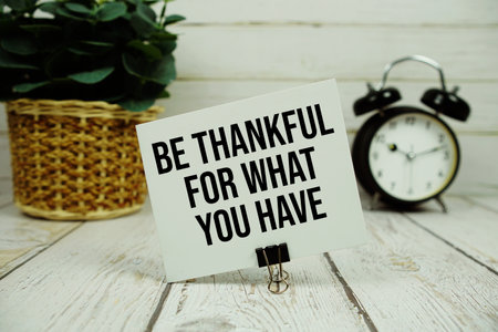 Be Thankful For What You Have text on paper card with alarm clock on wooden backgroundの写真素材