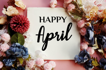 Happy April text with flowers decorations on pink backgroundの写真素材