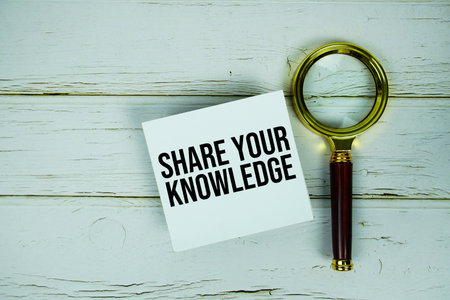 Share Your Knowledge text message on paper with magnifying glass on wooden backgroundの写真素材