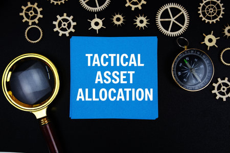 Tactical Asset Allocation text message on sticky note with magnifying glass and compass on black backgroundの写真素材
