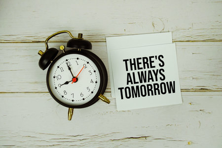 There's Always Tomorrow text message on paper with alarm clock on wooden backgroundの写真素材
