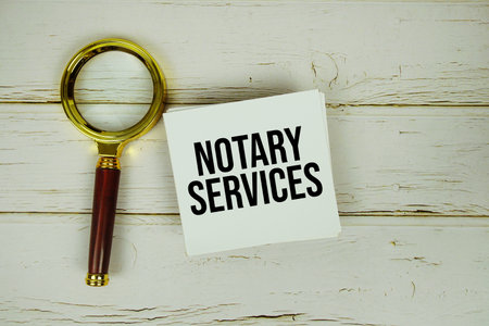 Notary Services text message on paper with magnifying glass on wooden backgroundの写真素材