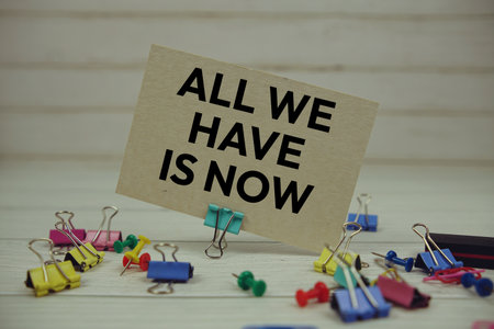 All We Have Is Now text on paper card with stationary on wooden backgroundの写真素材