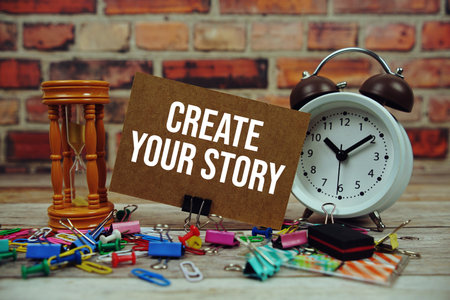 Create Your Story text on paper card with alarm clock and stationary on wooden backgroundの写真素材