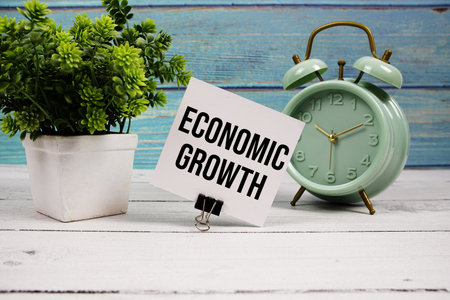 Economic Growth text written on paper card with alarm clock on wooden backgroundの写真素材