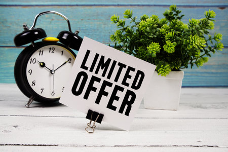 Limited Offer text written on paper card with alarm clock on wooden backgroundの写真素材