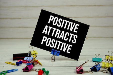 Positive Attracts Positive text on paper card with stationary on wooden backgroundの写真素材