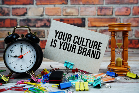 Your Culture Is Your Brand text on paper card with alarm clock and stationary on wooden backgroundの写真素材