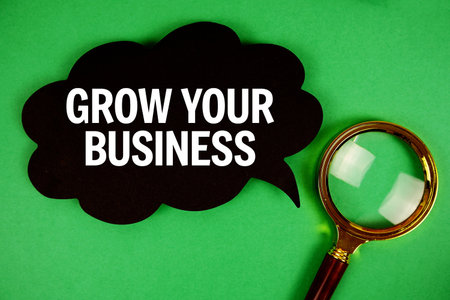 Grow Your Business text with speech bubble and magnifying glass on green backgroundの写真素材