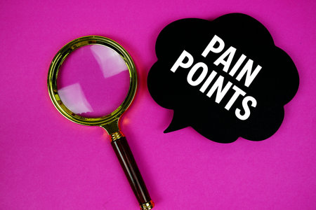 Pain Points text with speech bubble and magnifying glass on pink backgroundの写真素材