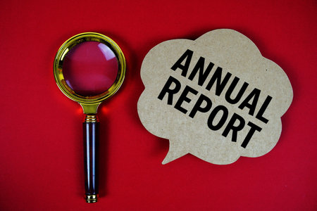 Annual Report text with speech bubble and magnifying glass on red backgroundの写真素材