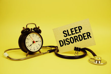 Sleep Disorder text on speech bubble with alarm clock and stethoscope on yellow background, Healthy conceptの写真素材