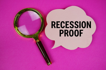 Recession Proof text with speech bubble and magnifying glass on pink backgroundの写真素材