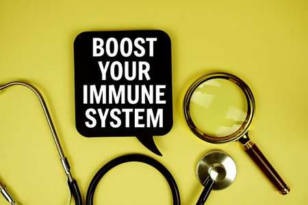 Boost Your Immune System text message on paper card with stethoscope magnifying glass on yellow backgroundの写真素材