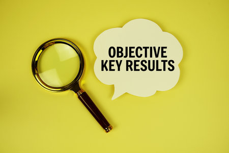 Objective Key Results text with speech bubble and magnifying glass on yellow backgroundの写真素材