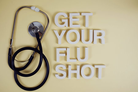 Get Your Flu Shot alphabet letters with stethoscope top view on yellow background