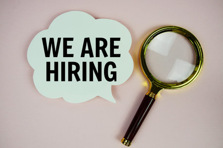 We Are Hiring text with speech bubble and magnifying glass on pink backgroundの写真素材