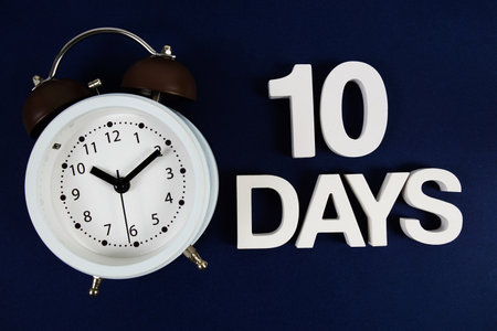 10 Days alphabet letters with alarm clock on navy blue backgroundの写真素材