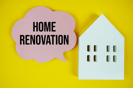 Home Renovation text message on speech bubble with house model on yellow backgroundの写真素材