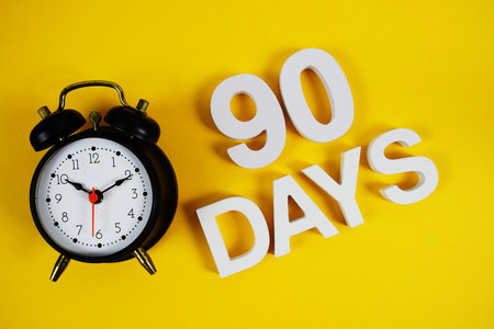 90 Days alphabet letters with alarm clock on yellow backgroundの写真素材