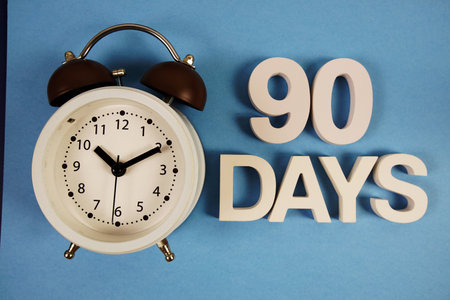 90 Days alphabet letters with alarm clock on blue backgroundの写真素材