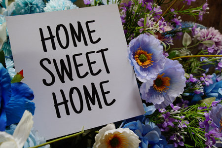 Home sweet home text write on paper card with flowers decoration on wooden backgroundの写真素材