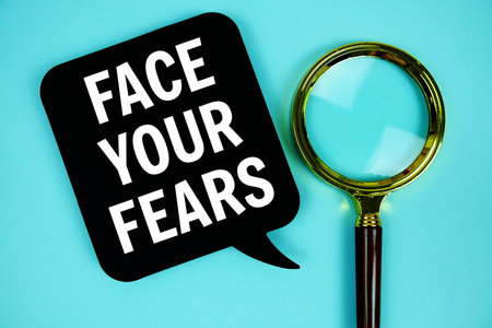 Face Your Fears text with speech bubble and magnifying glass on blue backgroundの写真素材