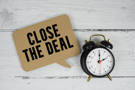 Close the Deal text with alarm clock on wooden backgroundの写真素材