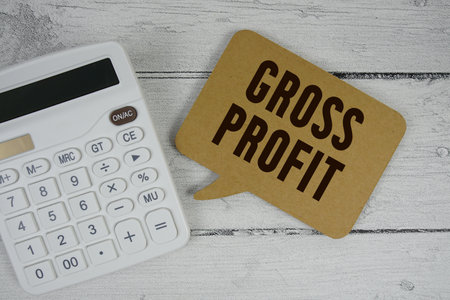 Gross Profit (GP) text with calculator on wooden backgroundの写真素材