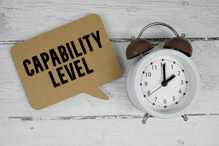 Capability Level text with alarm clock on wooden background