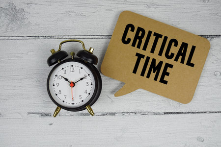 Critical Time text with alarm clock on wooden backgroundの写真素材