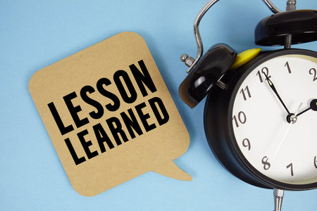 Lesson Learned text with alarm clock on blue backgroundの写真素材