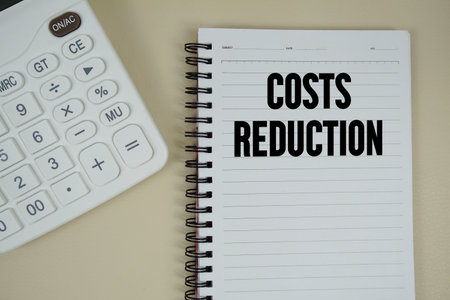 Costs Reduction text with calculator phrase of business and financial conceptの写真素材