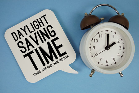 Daylight Saving Time text with alarm clock on blue backgroundの写真素材
