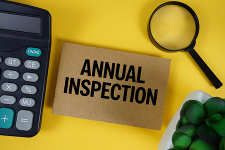 Annual Inspection text with magnifying glass anc calculator on yellow backgroundの写真素材