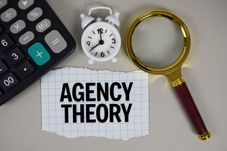 Agency Theory text with alarm clock, magnifying glass anc calculator on gray backgroundの写真素材