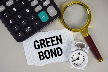 Green Bond text with alarm clock, magnifying glass anc calculator on gray backgroundの写真素材