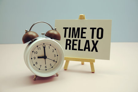 Time To Relax text on paper card with alarm clock on pink backgroundの写真素材