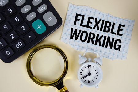 Flexible Working text with alarm clock, magnifying glass anc calculator on yellow backgroundの写真素材