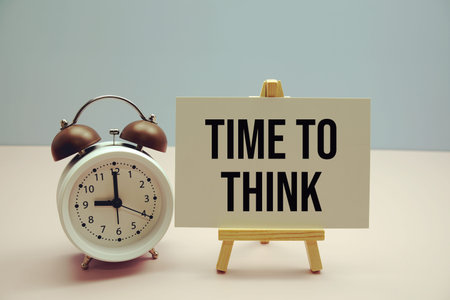 Time To Think text on paper card with alarm clock on pink background