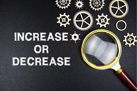 Increase Or Decrease text message with magnifying glass on black background