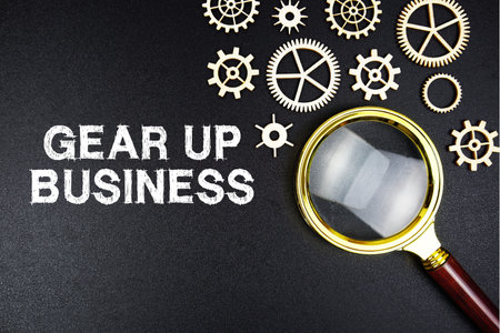 Gear Up Business text message with magnifying glass on black background