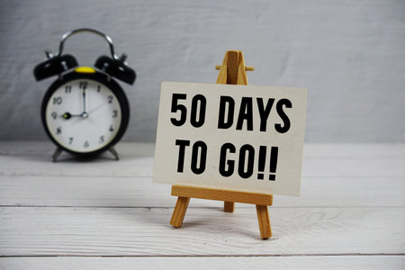 50 Days To Go! text with easel and alarm clock on wooden backgroundの写真素材