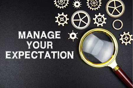Manage Your Expectations text message with magnifying glass on black backgroundの写真素材