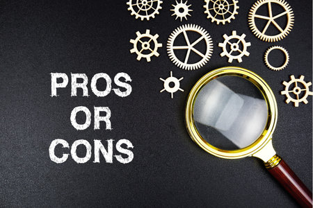 Pros or Cons? text message with magnifying glass on black backgroundの写真素材