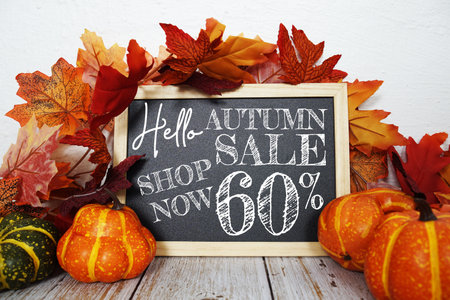 Autumn Sale 60% off text with maple leaf decoration on wooden backgroundの写真素材