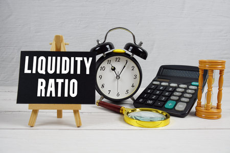 Liquidity Ratio text with alarm clock and calculator on wooden background