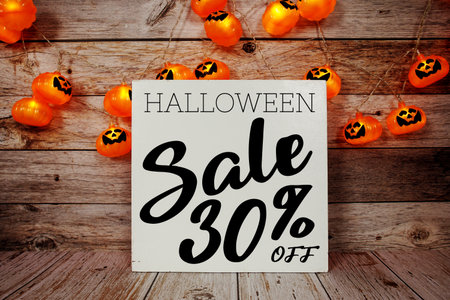 Halloween Sale 30% off text with LED pumpkin decoration on wooden backgroundの写真素材